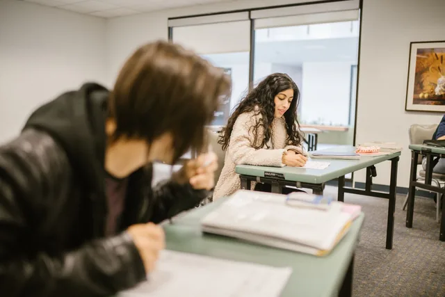 Dos alumnos estudiando en un aula.